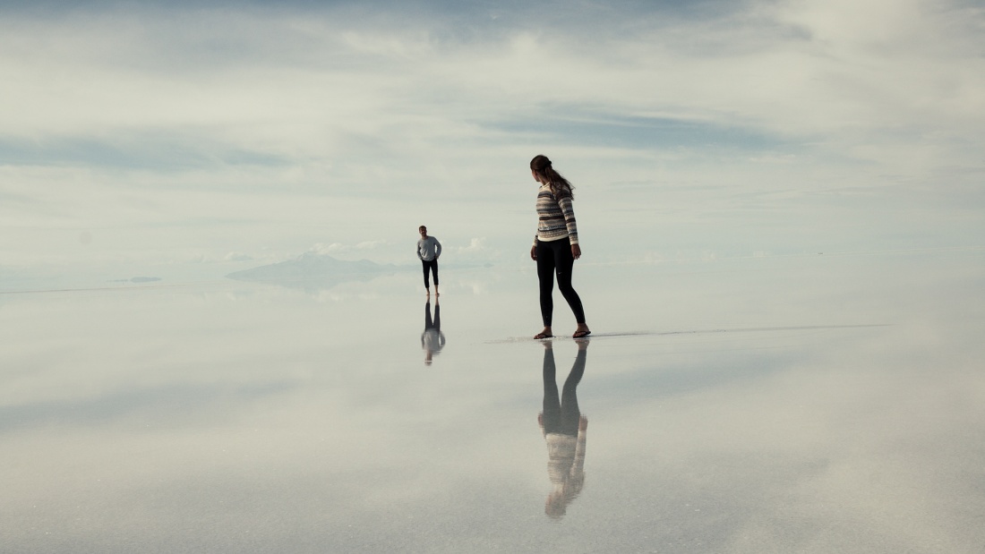zwei Menschen laufen auf einer sich spiegelnden Oberfläche