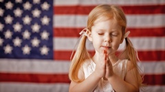 Mädchen vor Amerika Flagge betet