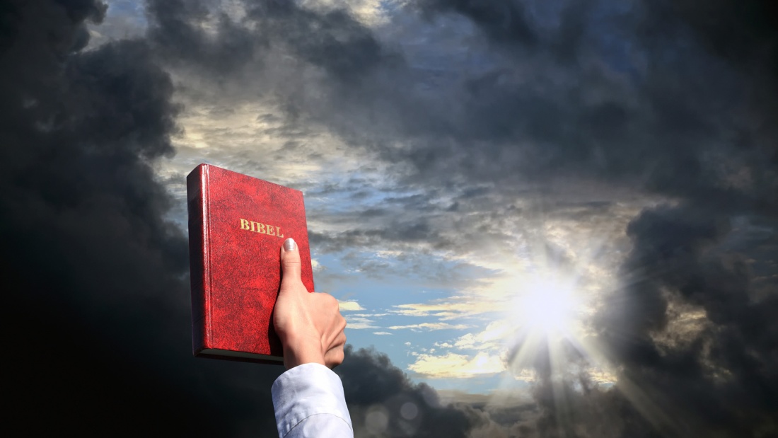 Rote Bibel vor dramatischem Himmel