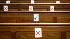 Kirchenbänke, bei denen einige Plätze, als nicht zu benutzen, markiert sind