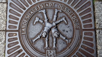 Radschläger Figuren auf Gullideckel in Düsseldorf