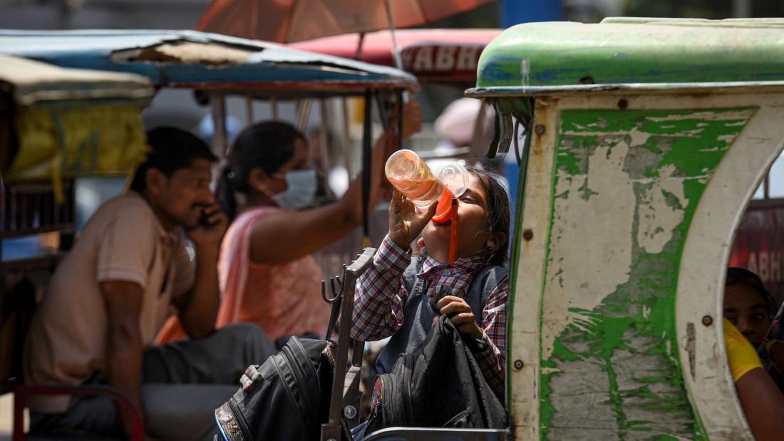 Eine Frau trinkt in Indien aus einer Flasche