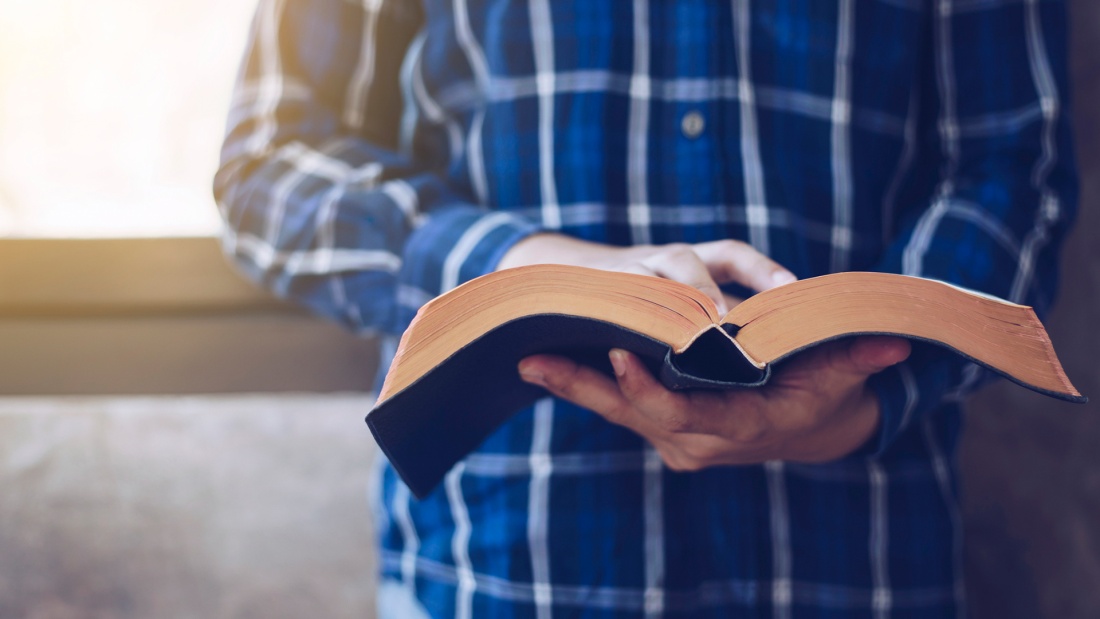 Junger Mann liesst in der Bibel