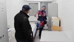 Manuela Heyns von der Ev.-luth. Tabita Kirchengemeinde Ottensen zeigt einem der neuen Bewohner seinen Containerplatz im Rahmen des Winternotprogramms. 