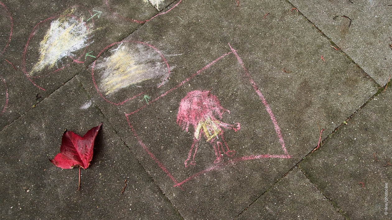 Kinderzeichnung mit Kreide auf Straße.