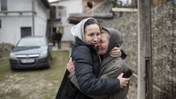 Olia (rechts) umarmt ihre Nachbarin, die nach Butscha (Ukraine) zurückkehrt