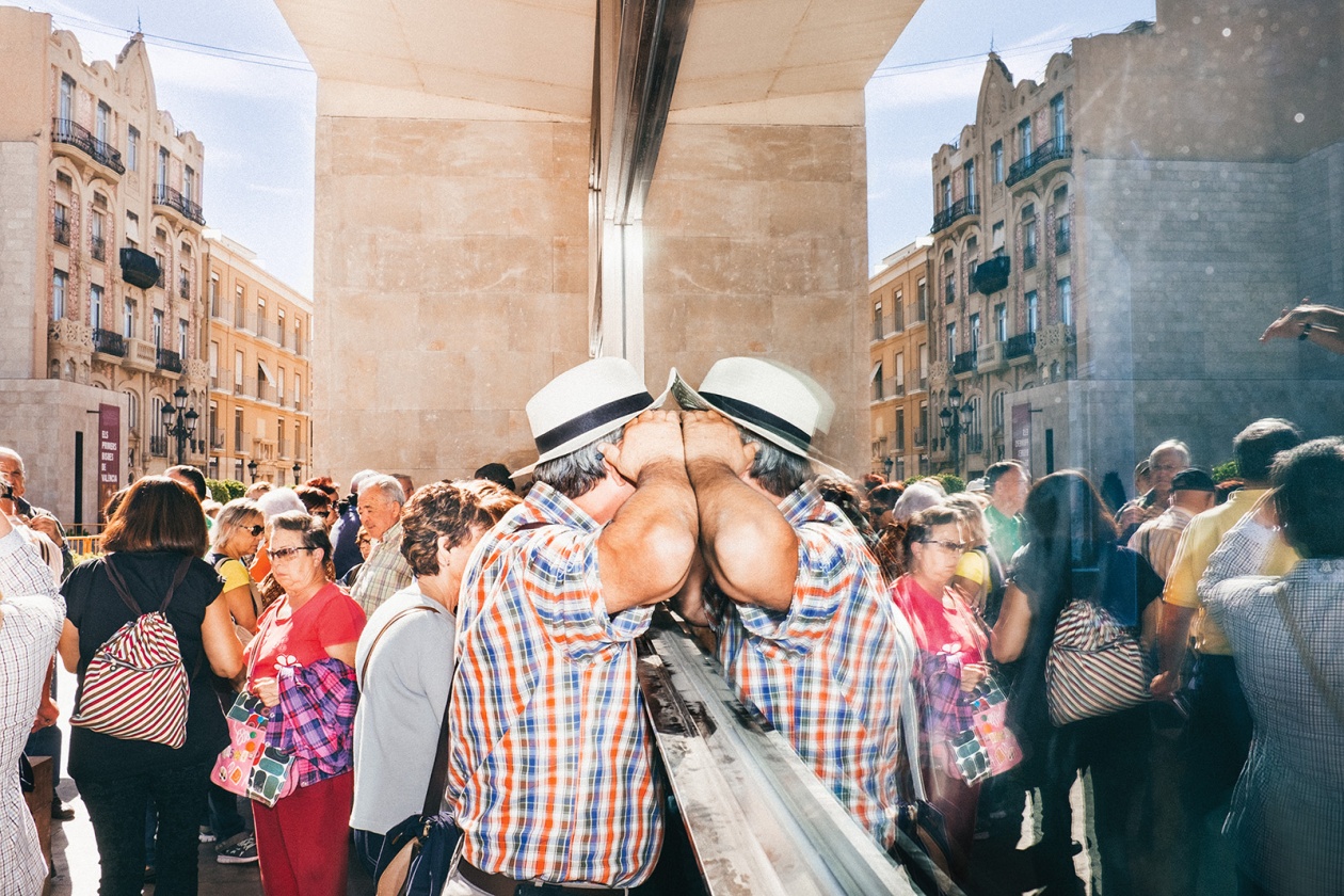 Ein Mann einer Touristengruppe schaut durch eine Scheibe auf dem Plaça de Dècim Juni Brut. Spanien, Valencia, 24. Oktober 2014