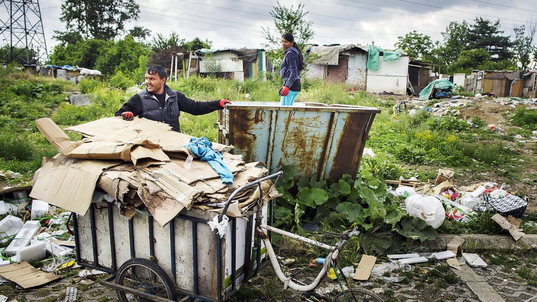 Ein Mann lädt am 28. Mai 2015 Pappe von einem selbstgebauten Fahrrad in einen Container am Rande einer Romasiedlung in Belgrad. 