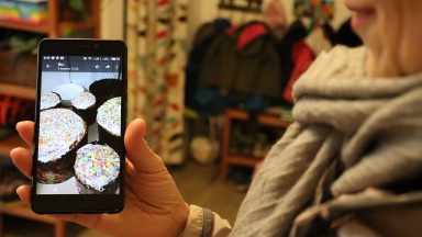 Ukrainerin zeigt auf ihrem Smartphone ein Bild des Osterkuchens (Paska)