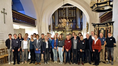 Teilnehmer und Dozenten des Jugend-Orgelforums Stade stehen in der Kirche St. Cosmae vor der Huß/Schnitger-Orgel von 1675