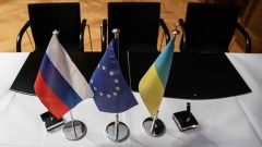 Die Flaggen von Russland, der EU und der Ukraine, stehen im Wirtschaftsministerium auf einem Tisch vor einer Pressekonferenz