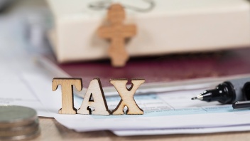 Holzbuchstaben "TAX" (Steuer) auf Steuererklärung.
