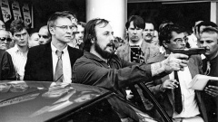 Der Bankräuber und Geiselnehmer Hans-Jürgen Rösner spricht am 18.08.1988 mit vorgehaltener Waffe zu Journalisten, die den Fluchtwagen umringen. Hinter Rösner steht der deuusche Journalist Udo Röbel, bevor er in das Fluchtauto steigt, um Rösner und Dieter D