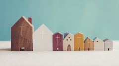 Miniatur-Holz-Häuser mit Kreuz auf Fassade