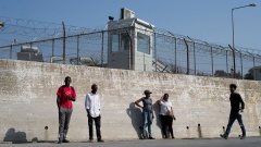 Eine Gruppe von Migranten steht an einer Mauer des völlig überfüllten Flüchtlingslagers Moria auf der Insel Lesbos im Ägäischen Meer. 