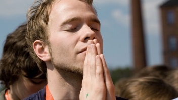 Ein junger Mann betet bei der Christival-Abschlussfeier in Bremen 2008.