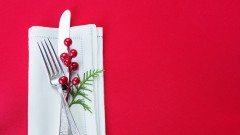 Messer und Gabel liegen auf einer weihnachtlich gedekten Tafel.