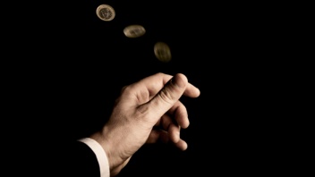 Hand schnippt Euro-Münze in die Luft