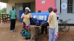 Eine Bäuerin holt am 18.01.2016 in einem Büro des Welternährungsprogramms (WFP) im Iganga Distrikt in Uganda eine Plastiktonne ab in der sie ihre Ernte lagern kann.