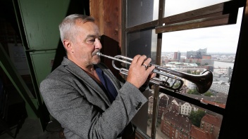 Michel-Türmer Horst Huhn spielt im 7. Stock des Turmes der Hauptkirche St. Michaelis in Hamburg aus einem Fenster Trompete. 