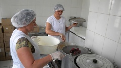 Frauen kochen in der Großküche der Landkooperative Obst und Gemüse ein.