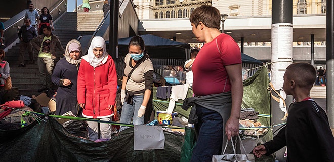 Ehrenamtliche Helfer verteilen am Ostbahnhof in Budapest Kleidung an Flüchtlinge