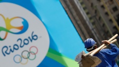 Ein Arbeiter läuft an einem Werbeplakat für Olympia 2016 in Rio vorbei.