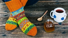 Warme Socken mit einer heißen Tasse Tee und Honig
