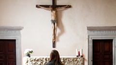 Eine Frau steht vor einem Altar in einer Kirche.