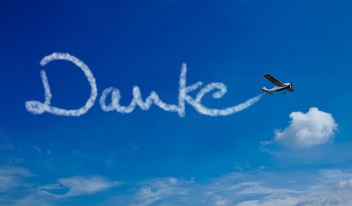 Flugzeug schreibt das Wort Danke an den blauen Himmel