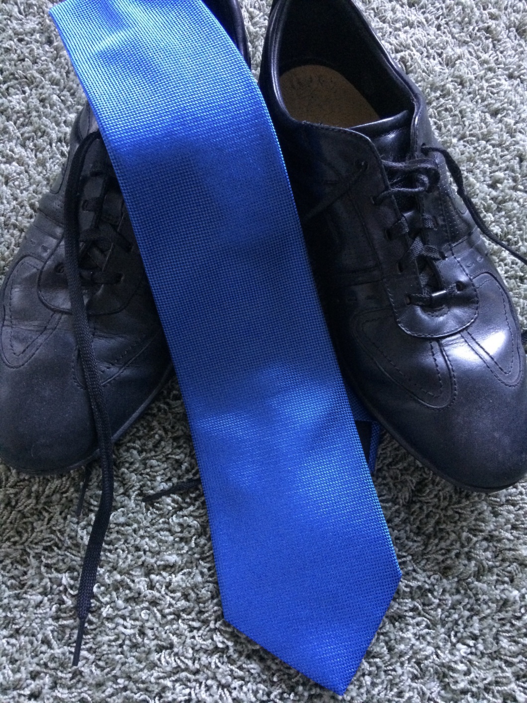 Ein Paar Sportschuhe und eine blaue Krawatte